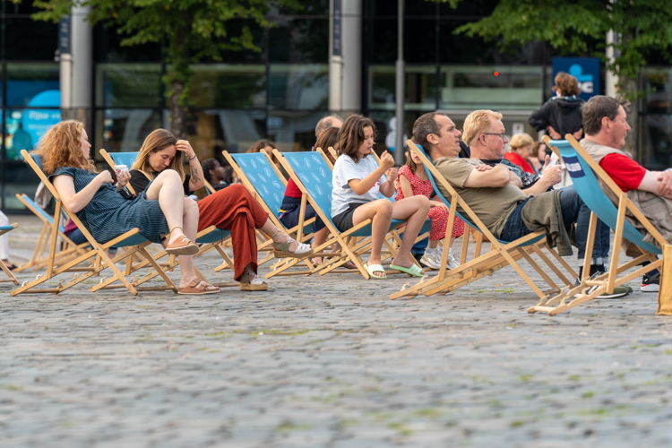 Luisterplaats met strandstoelen en videoscherm op het Mgr. Ladeuzeplein voor de beiaard van de Universiteitsbibliotheek