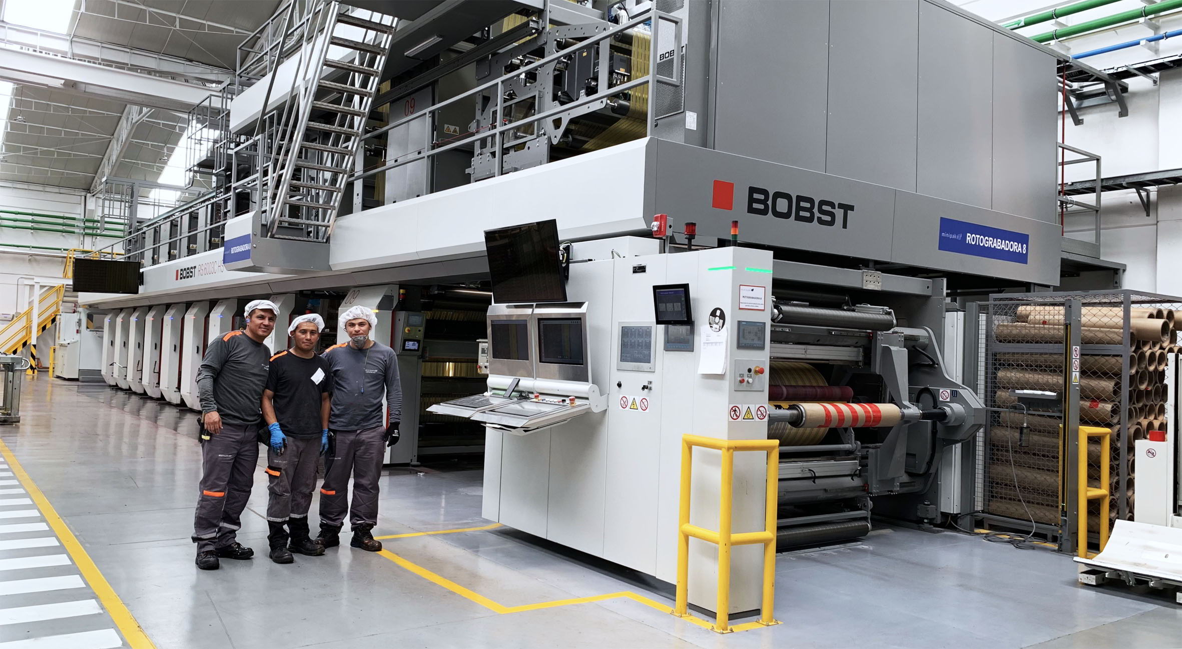 Operadores de prensa de Minipak frente a la prensa de huecograbado BOBST en la planta de producción del convertidor colombiano.