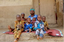 Rukkaya Mohammed*, a mother of seven including twins sits on a mat with her children at an internally displaced persons camp in Zurmi Local Government Area of Zamfara state