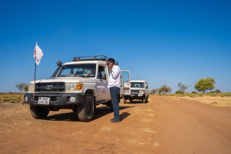 Een AZG-voertuig rijdt over de stoffige weg naar de nederzetting Jerbana, waar het team een mobiele kliniek runt die zowel ontheemden als de gastgemeenschap bedient. © Isaac Buay/MSF