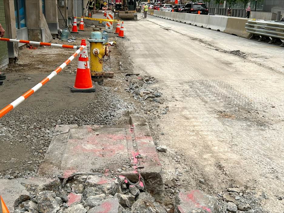 Sidewalk and roadway demolition in the former counterflow lane on Fifth Avenue
