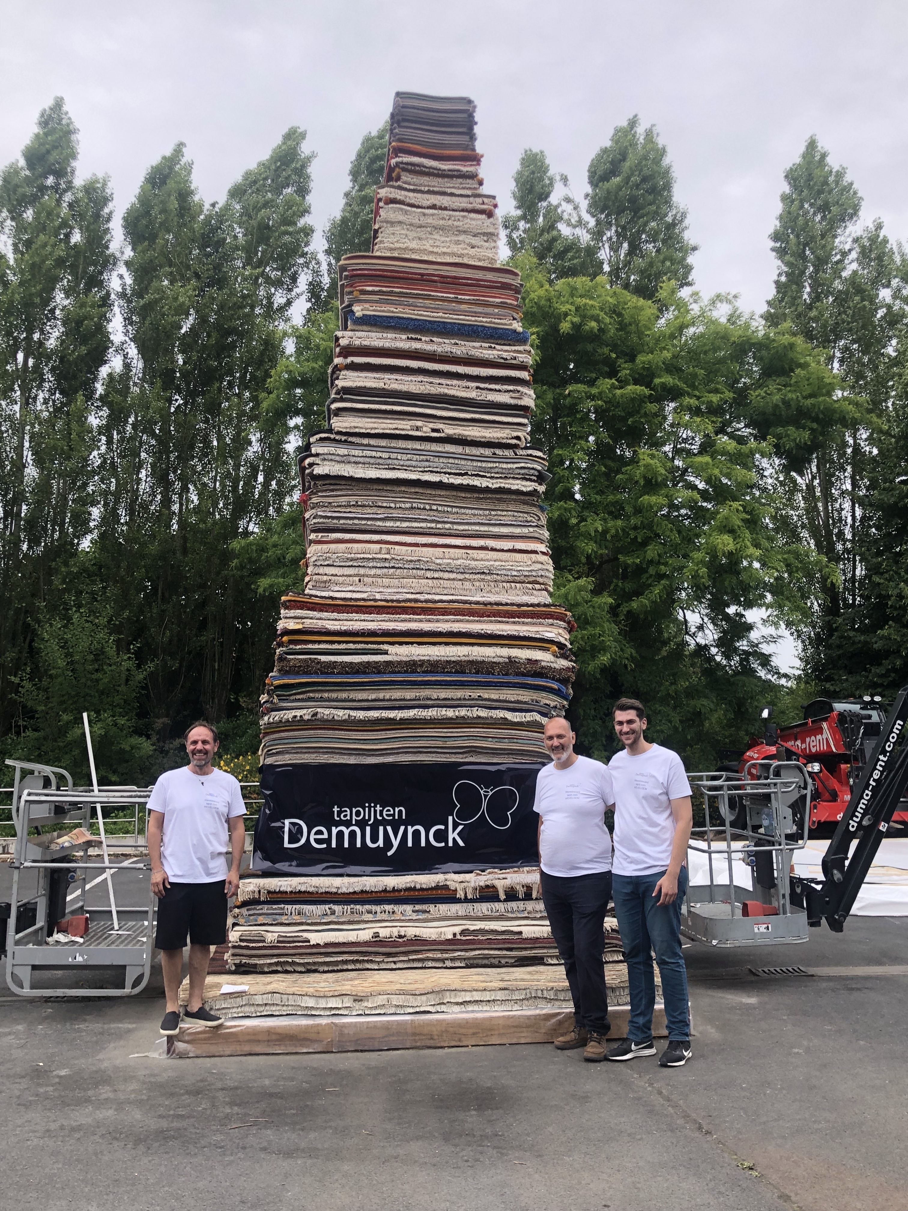 Na afloop poseerde Filip Demuynck (midden) samen met zijn zoon Cedric ​
en medewerker Laurent Alves voor de tapijtenstapel van 6,52 meter hoog.