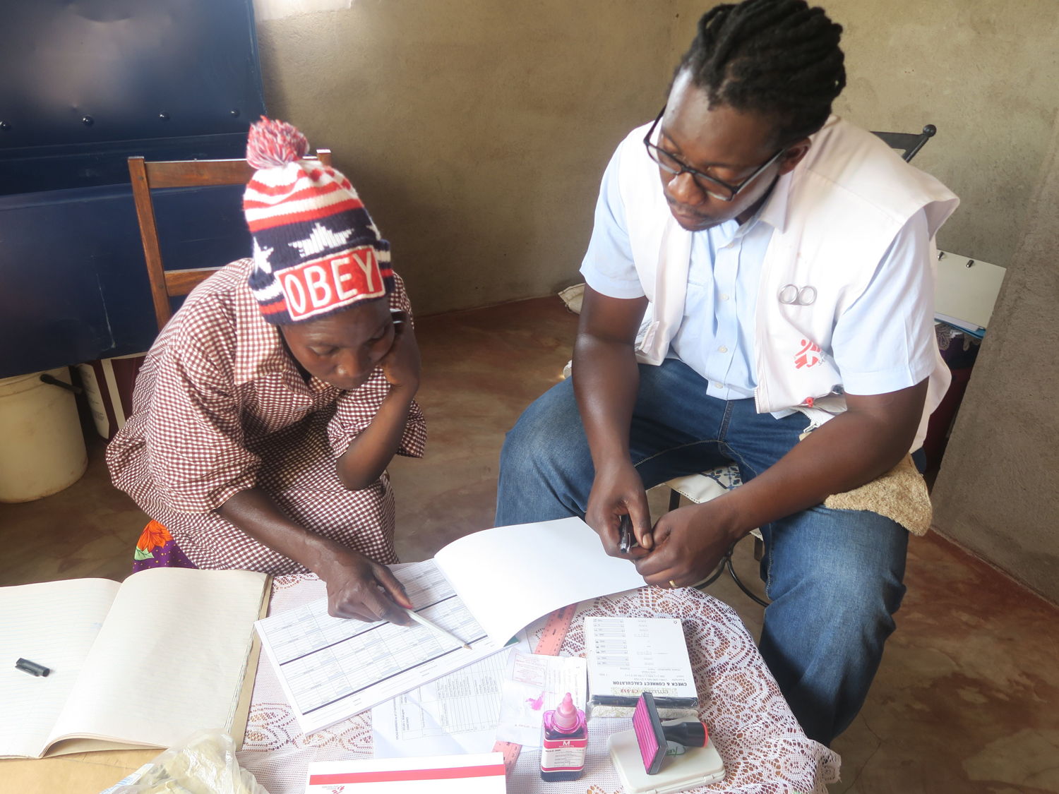 MSF nurse mentor, Tinashe Mbirimi (right) mentoring a village health worker, Rinet Zhou on how to register people living with HIV (PLHIV) to collect antiretroviral treatment using the Out of Facility Community ART Distribution (OFCAD) model in Mwenezi. Photographer: Gloria Ganyani