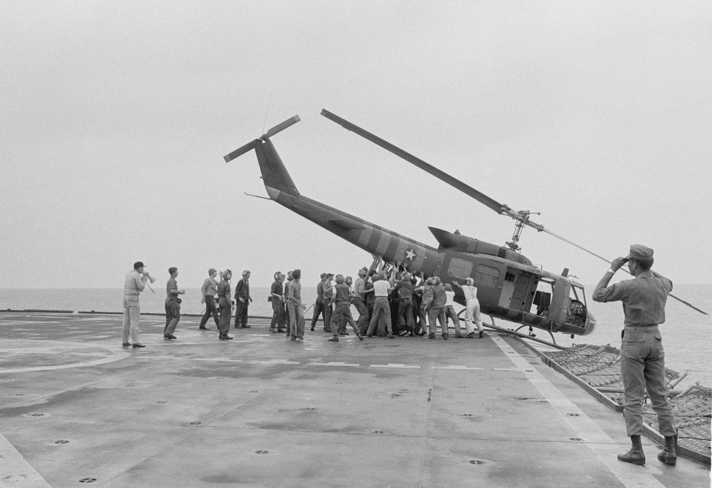 The Vietnam War - Aflevering 10: Amerikaanse soldaten duwen helikopter in zee tijdens evacuatie vanuit Saigon, 1975 - (c) AP Images