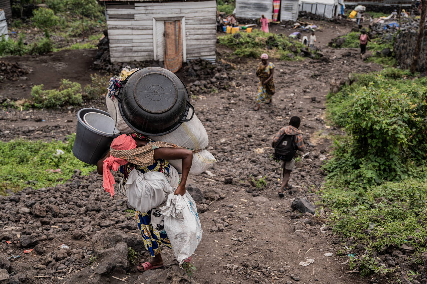 Title: IDPs leaving Goma camps Copyright: Jospin Mwisha Countries: Democratic Republic of Congo Date taken / Date Recorded: 11 February, 2025 Caption / Description: Des familles quittent les camps de Lushagala et Bulengo, portant leurs colis sur le dos et sur la tête, certains à pied tandis que d’autres paient des motos ou des camions pour se déplacer, selon leurs moyens. Inquiets, ils se demandent si ils retrouveront leur maison ou s’ils devront recommencer à zéro