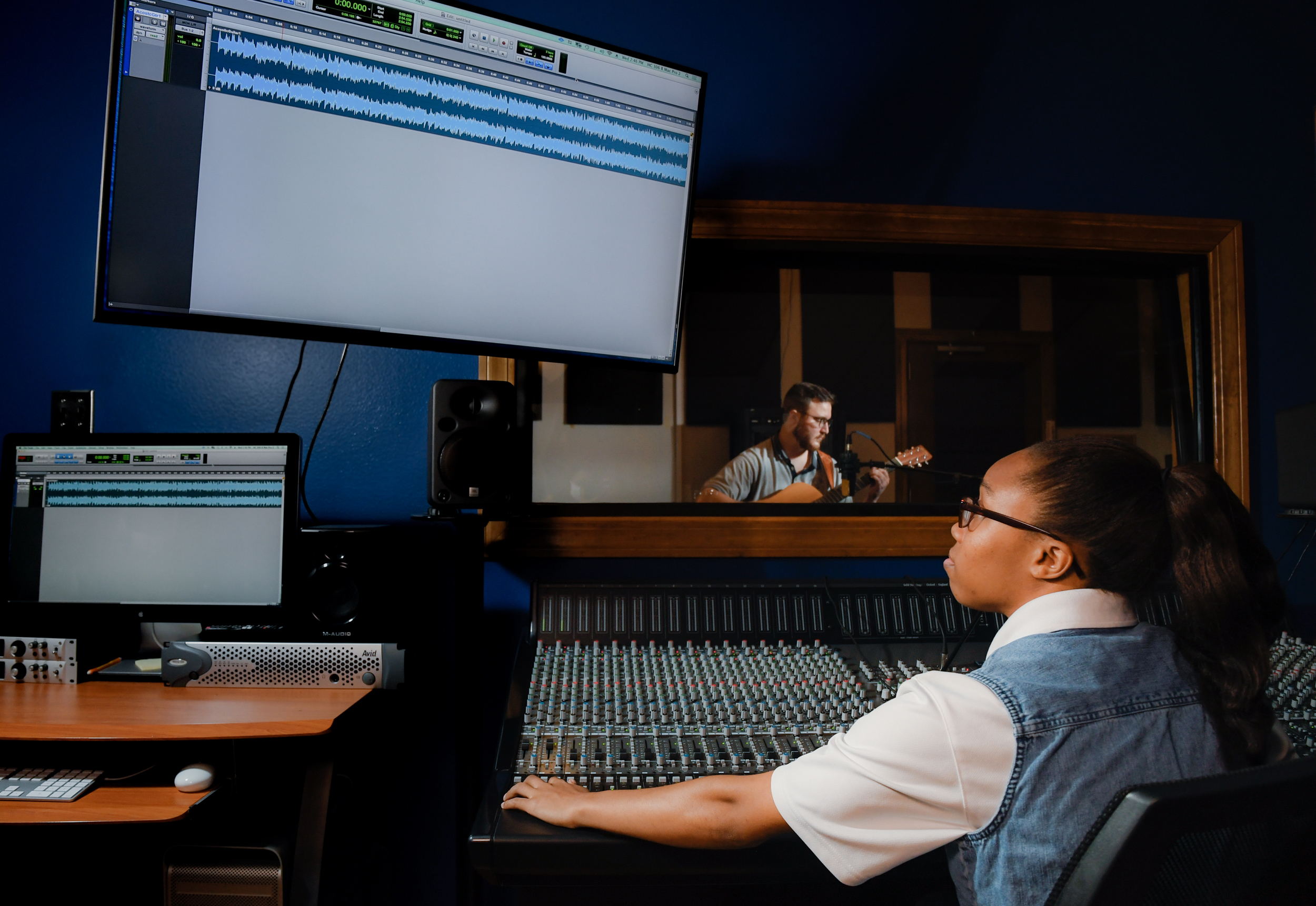 Will Flowers plays the guitar while Jalia Payne demonstrates how to record music with Louisiana Tech University’s new ORIGIN analogue in-line console for hybrid production environments.