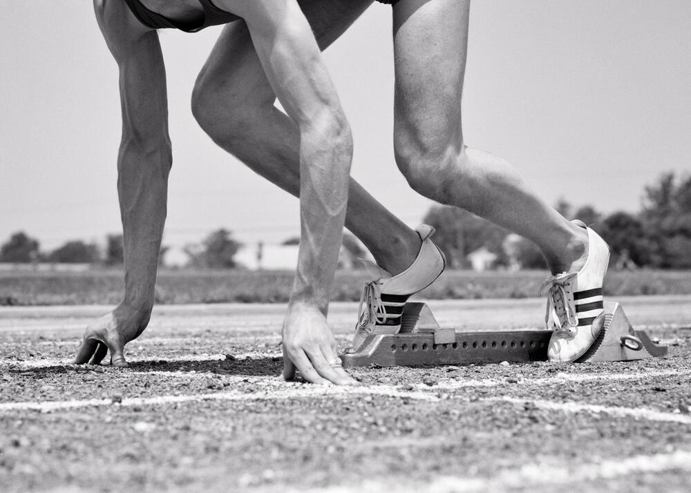 AKG8297754  1960s MAN ATHLETE TRACK RUNNER IN STARTING BLOCK IN CROUCHING POSITION © akg-images / ClassicStock / H. ARMSTRONG ROBERTS