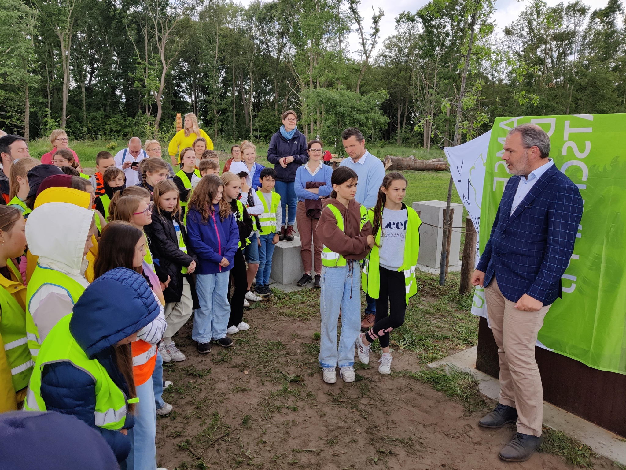 Vol spanning wachten de leerlingen op de onthulling van het infobord waarin hun tekeningen werden verwerkt
