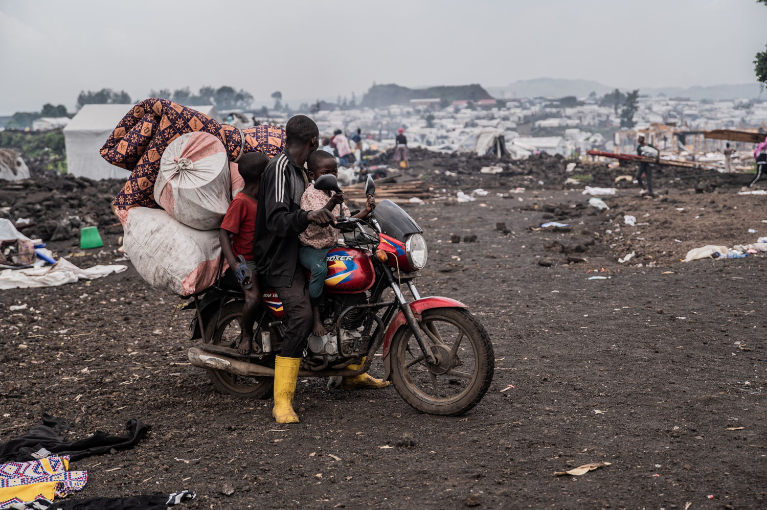 Title: IDPs leaving Goma camps Copyright: Jospin Mwisha Countries: Democratic Republic of Congo Date taken / Date Recorded: 11 February, 2025 Caption / Description: Des familles quittent les camps de Lushagala et Bulengo, portant leurs colis sur le dos et sur la tête, certains à pied tandis que d’autres paient des motos ou des camions pour se déplacer, selon leurs moyens. Page 4