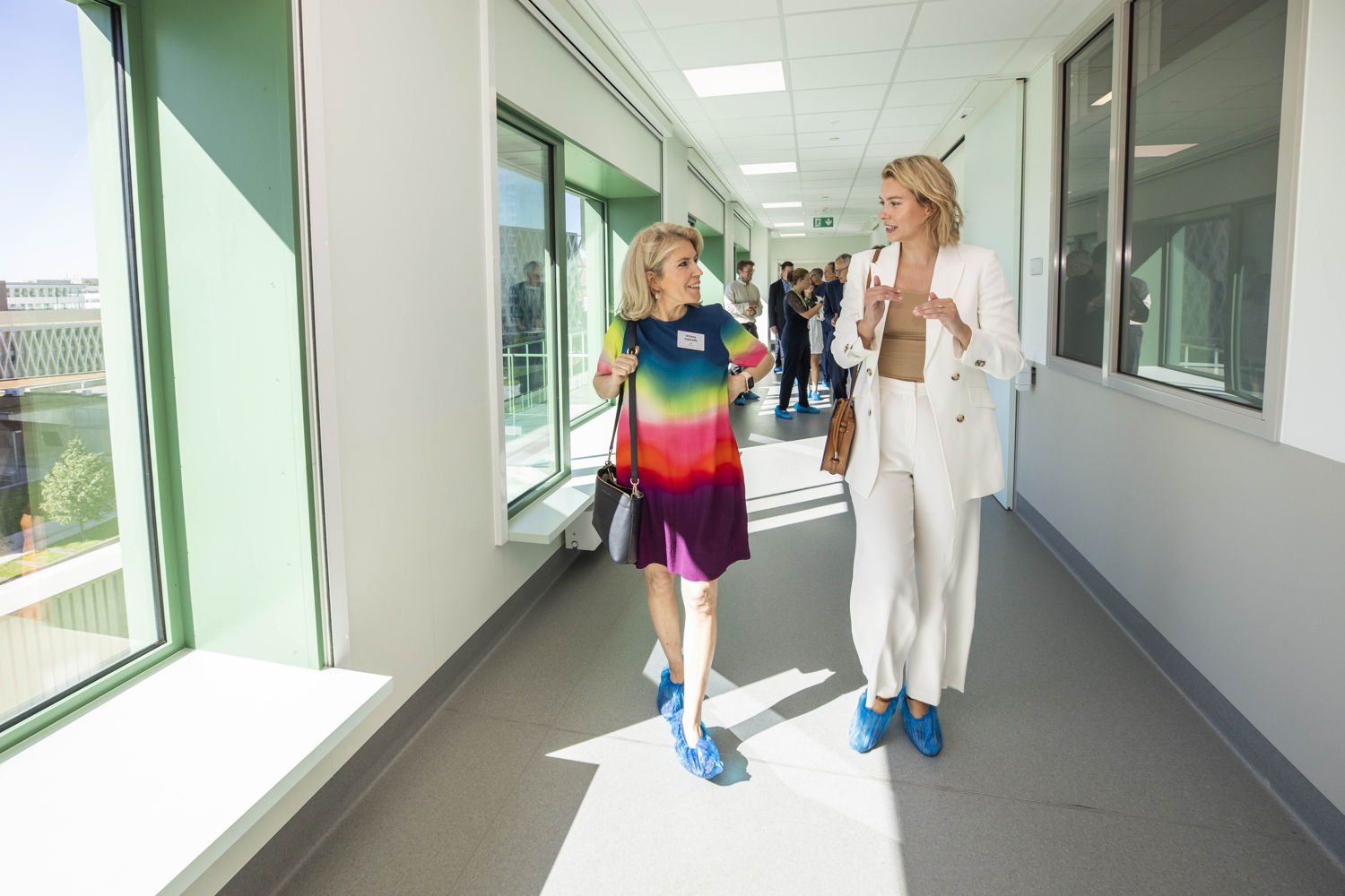(Vlnr) Willeke Dijkhoffz en Els van Doesburg brengen bezoeken het nieuwe ziekenhuis ZNA Cadix Ze dragen blauwe overschoenen omdat de vloer niet vuil te maken (foto: ZNA / Dirk Kestens)
