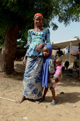 Habiba Saleh stands with her children at an internally displaced persons camp in Zurmi Local Government Area of Zamfara state.She, her husband and their 5 children fled their village during an attack by armed men. Now they live in the camp established in a school building, alongside many other displaced people.