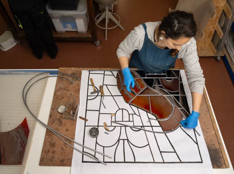 Emma Groult, glass conservator, assembling a section of the Saint-Louis window, by Andre Rinuy, from the Cathedrale Notre-Dame de Paris, damaged in the fire of April 2019. AKG11633866 ©  akg-images / Manuel Cohen