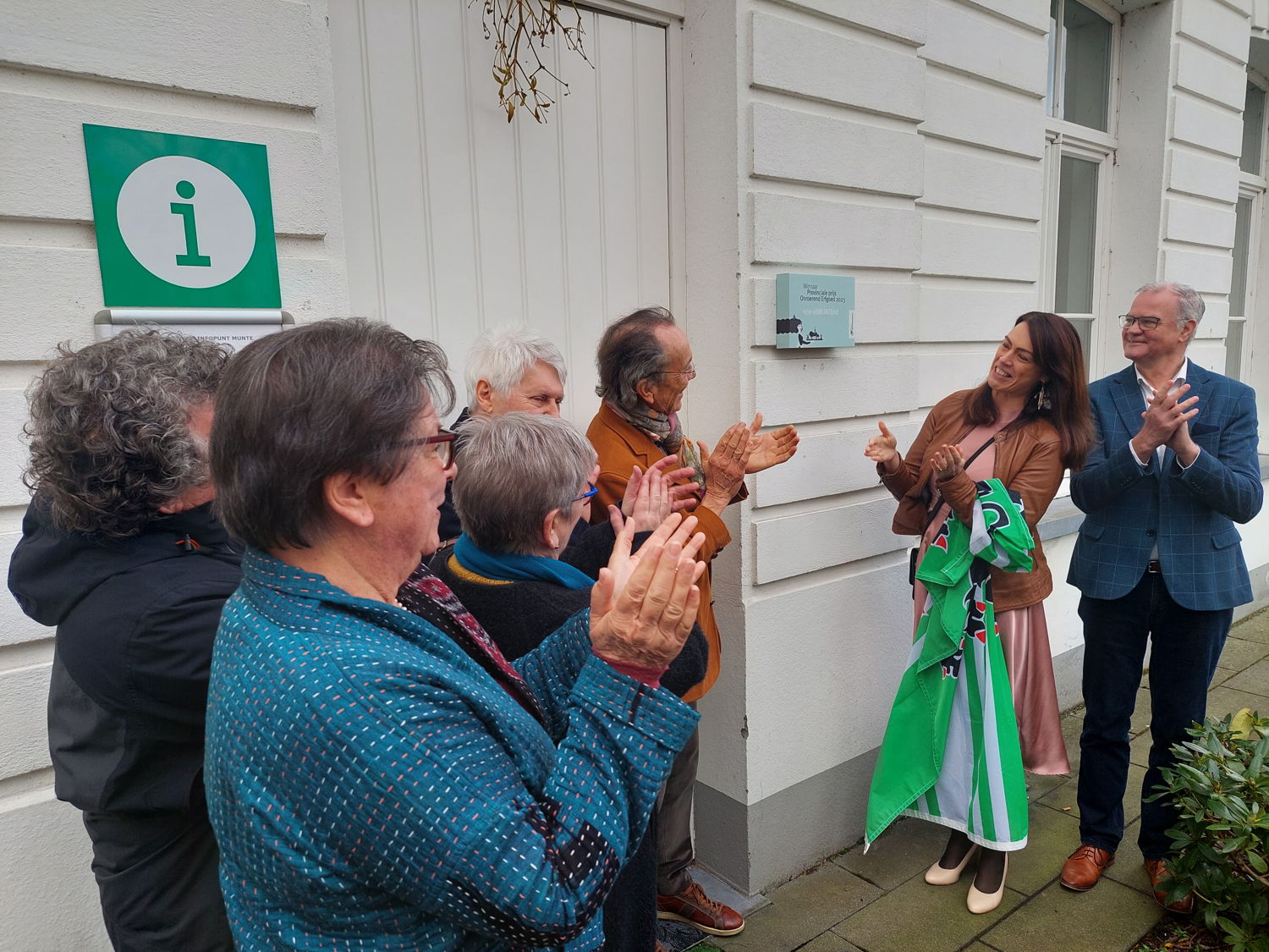 De onthulling van de gedenkplaat (links: leden van de vzw uitMUNTEnd, rechts: gedeputeerde An Vervliet en burgemeester Filip Thienpont)