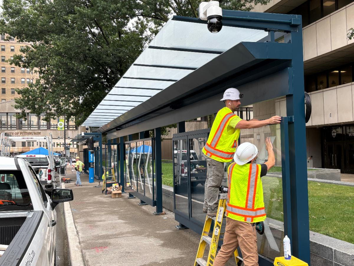Contractors place glass in the new West Oakland PRTX Station located on Forbes Avenue at Bouquet Street