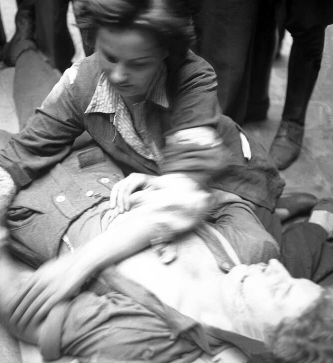Nurse Anita treating a wounded German, 21 August 1944. She is wearing an armband from the Commissariat Général à la Jeunesse - Équipes Nationales. AKG10792620 © René Zuber / akg-images
