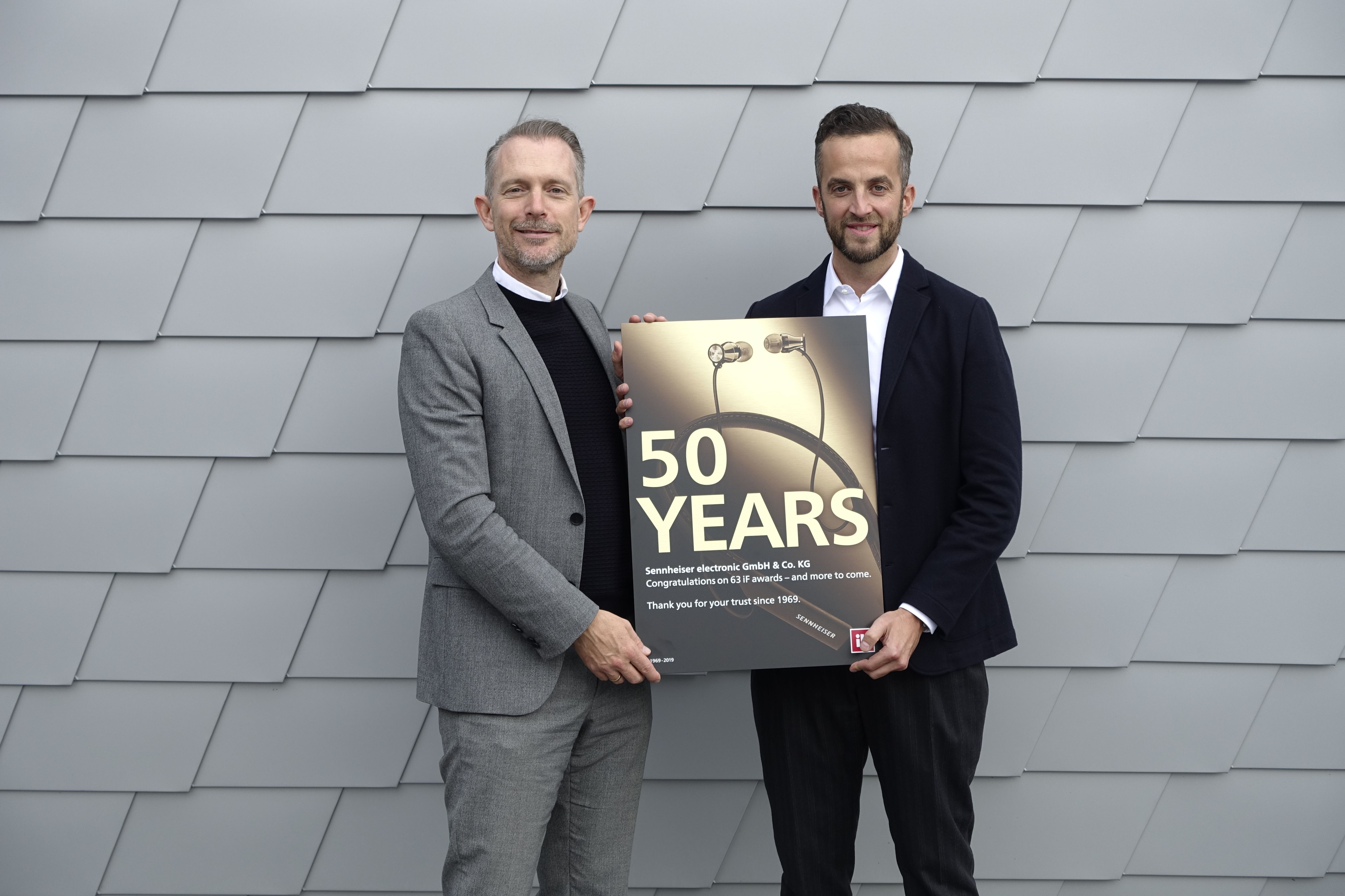 ​	Frank Zierenberg (links), Project Director beim iF, überreicht Oliver Berger, Global Head of Brand and Design Management bei Sennheiser, die Urkunde für 50 Jahre iF DESIGN AWARDS