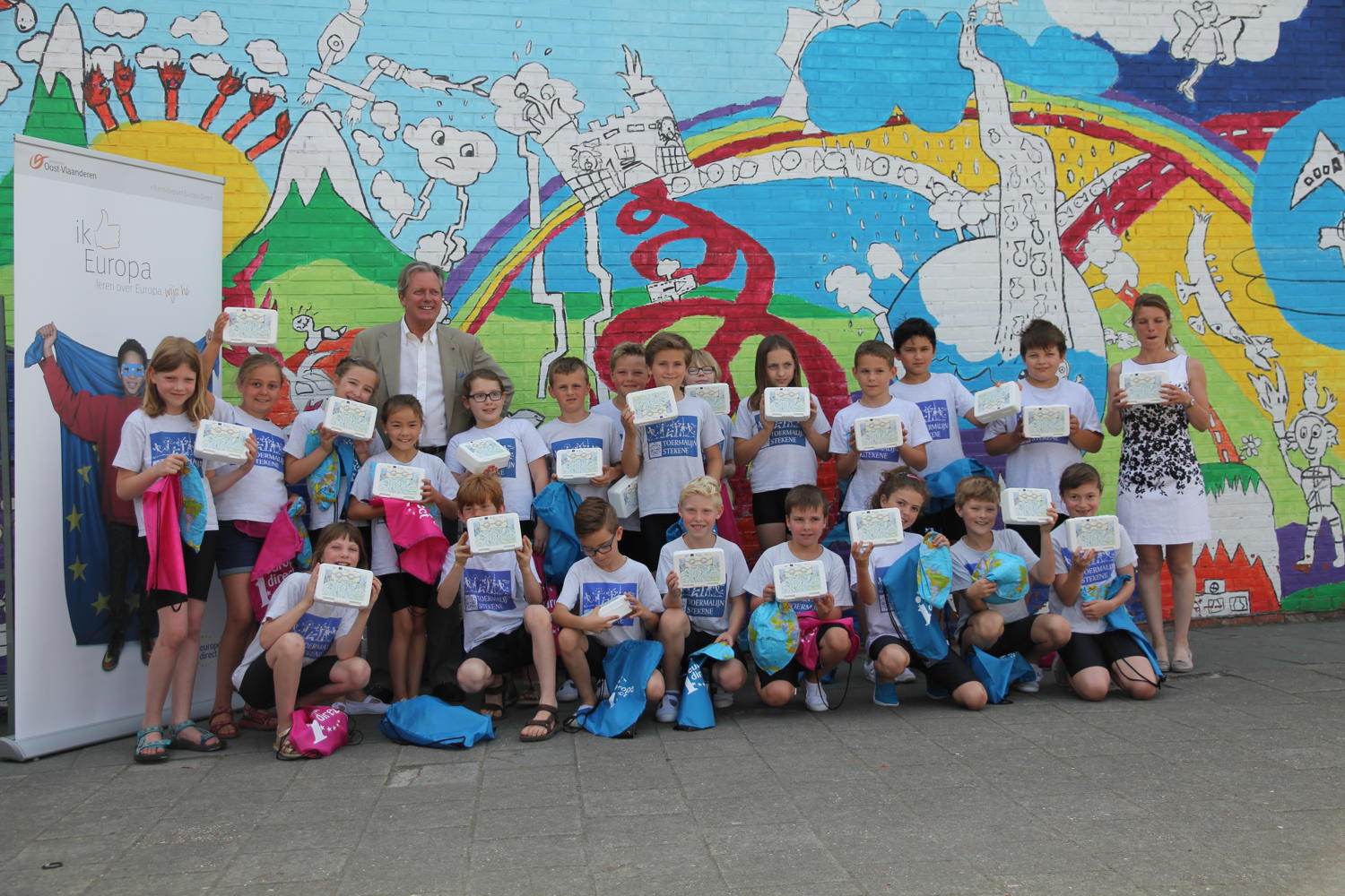 Gedeputeerde Geert Versnick en winnaar Elfien samen op de foto met de klas