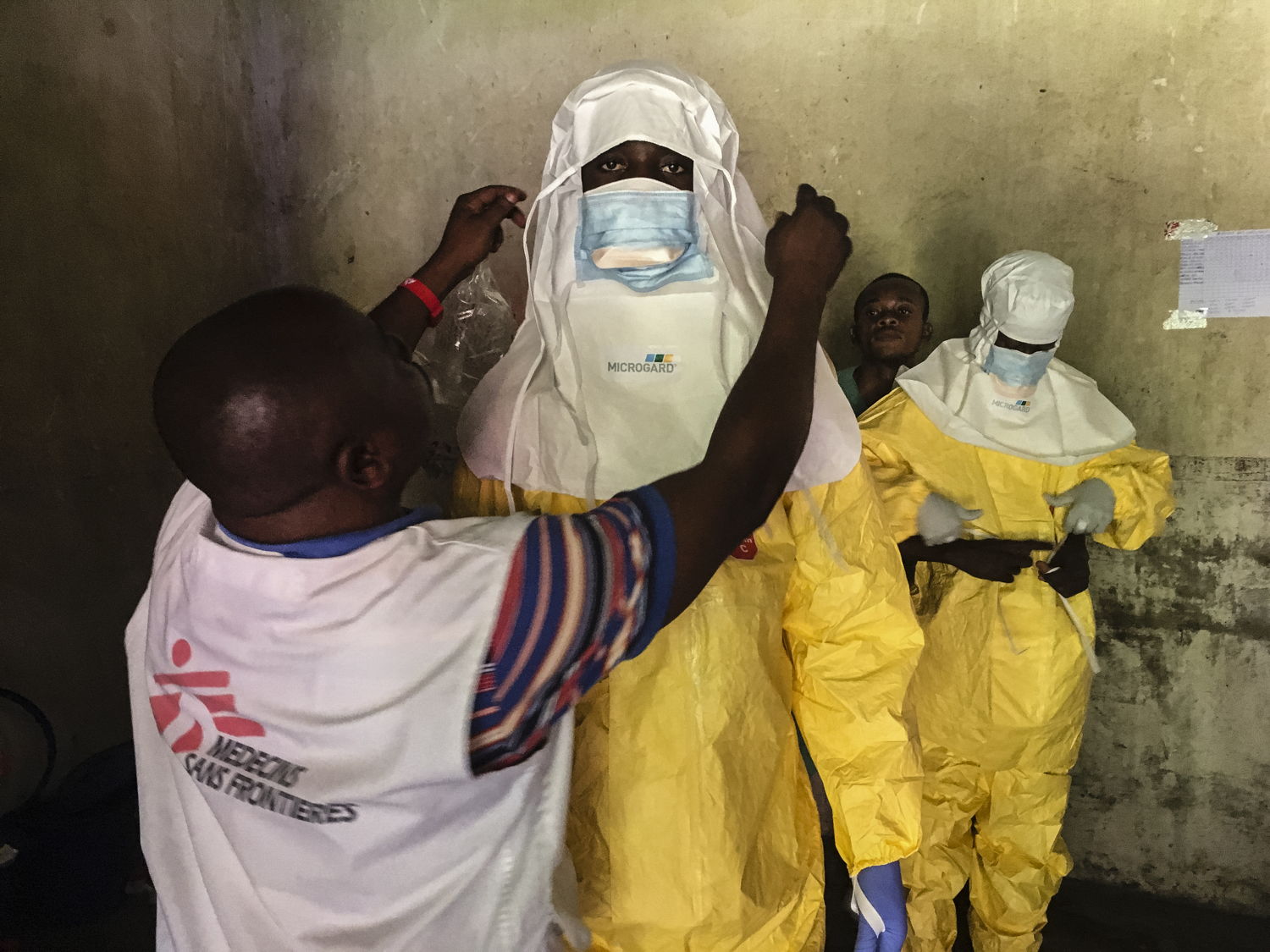 Trabajadores humanitarios de MSF se visten con el equipo de protección personal en el Centro de tratamiento de Ébola de Bikoro © Hugues Robert/MSF