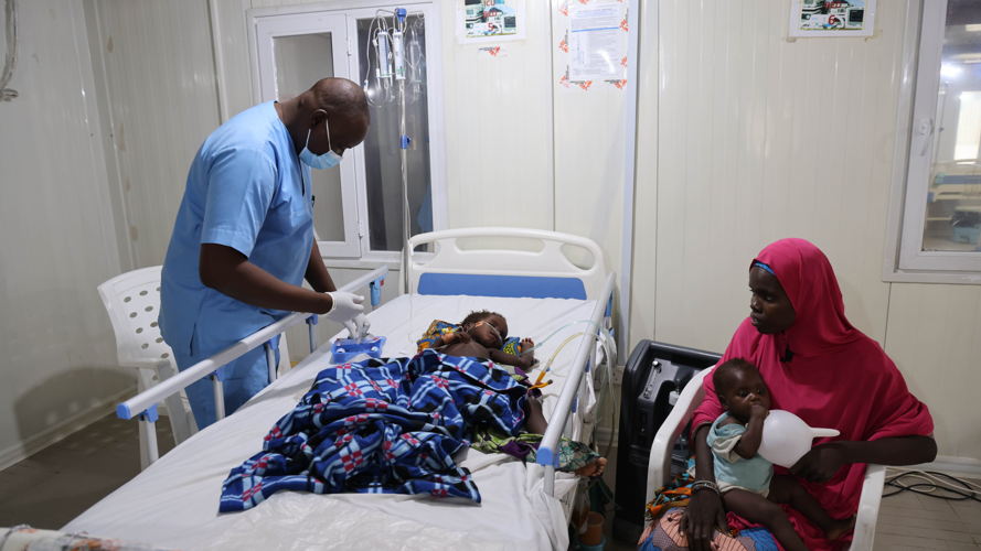 MSF nurse attends to a critically ill child admitted at the emergency room of Nilefa kiji while the mother looks on. Copyright MSF