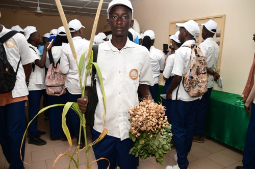 A student with a sample of millet and groundnut 