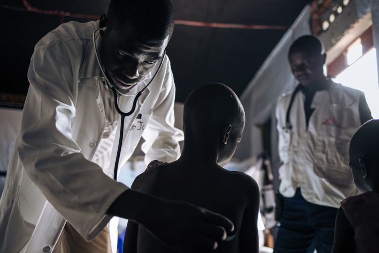 Dr. Justin Embani Drudra soigne un enfant de neuf ans qui souffre de la rougeole  © Alexis Huguet