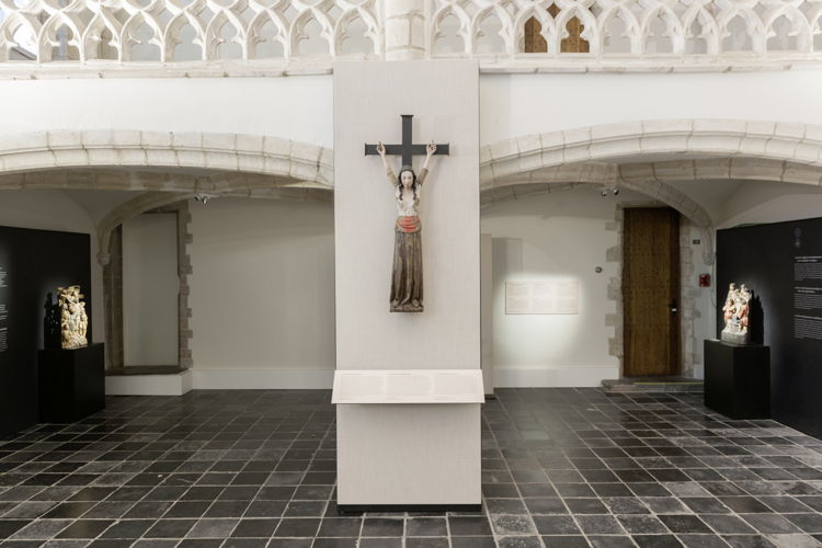 Zaalzicht van de Naussaukapel met een beeldhouwwerk van de Heilige Wilgefortis (bruikleen uit Museum Hof van Busleyden) Ⓒ KBR