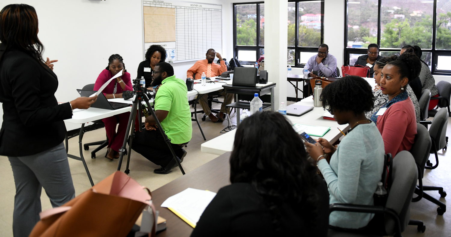 Facilitators engage participants in practical media relations sessions.