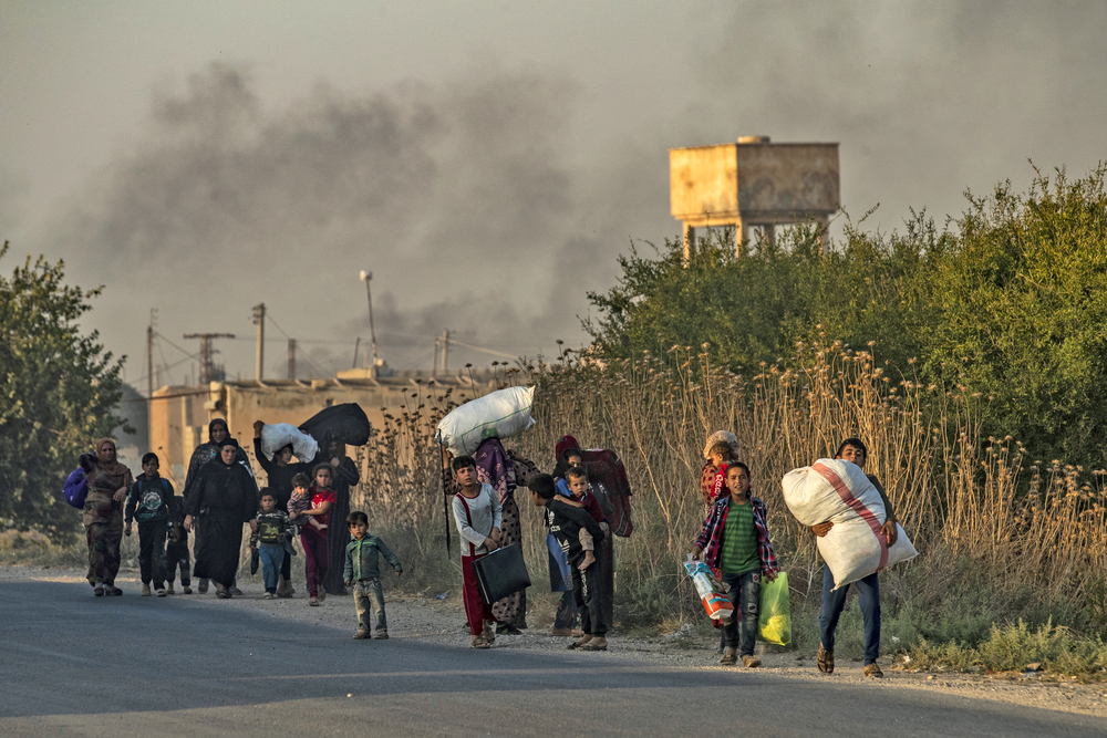 Syrische burgers op de vlucht voor de bombardementen op de stad Ras al-Ain in noordoostelijke provincie Hasakeh naast de grens met Turkije op 9 oktober 2019