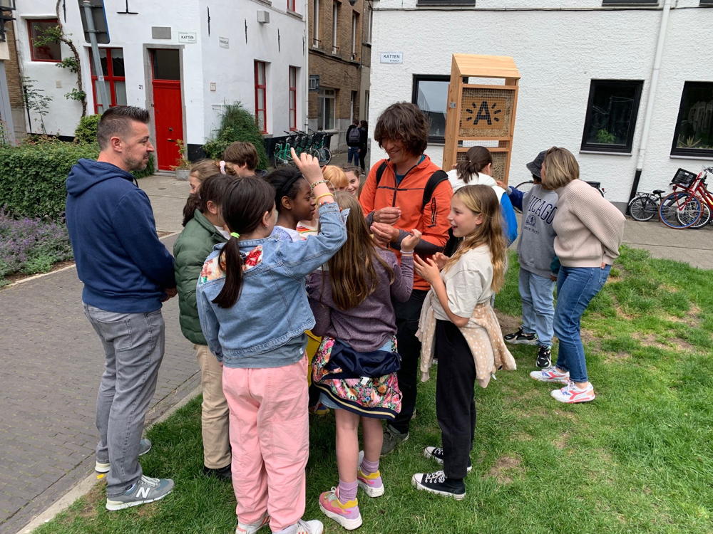 Joeri Cortens (Natuurpunt vzw) geeft uitleg over bijen aan leerlingen van basisschool De Kleine Jacob aan het bijenhotel in de Haantjeslei