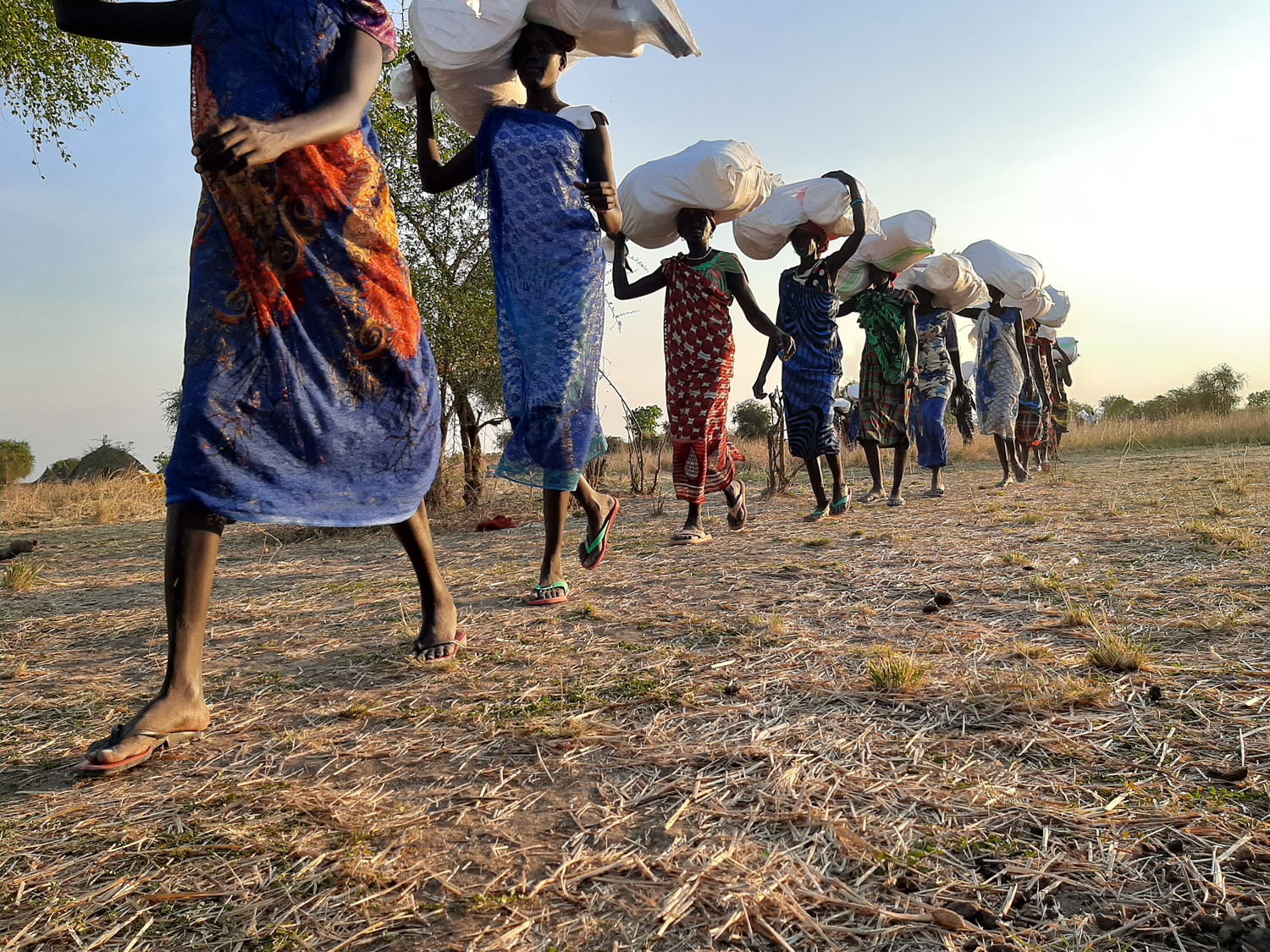 Women from Riang, Jonglei state, carry items that MSF will distribute to local families. Hiring only women as porters is a way to support the most vulnerable people in the community. Copyright: Damaris Giuliana/MSF