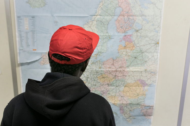 Een jonge migrant bestudeert een kaart van Europa in de humanitaire hub. © Albert Masias / AZG