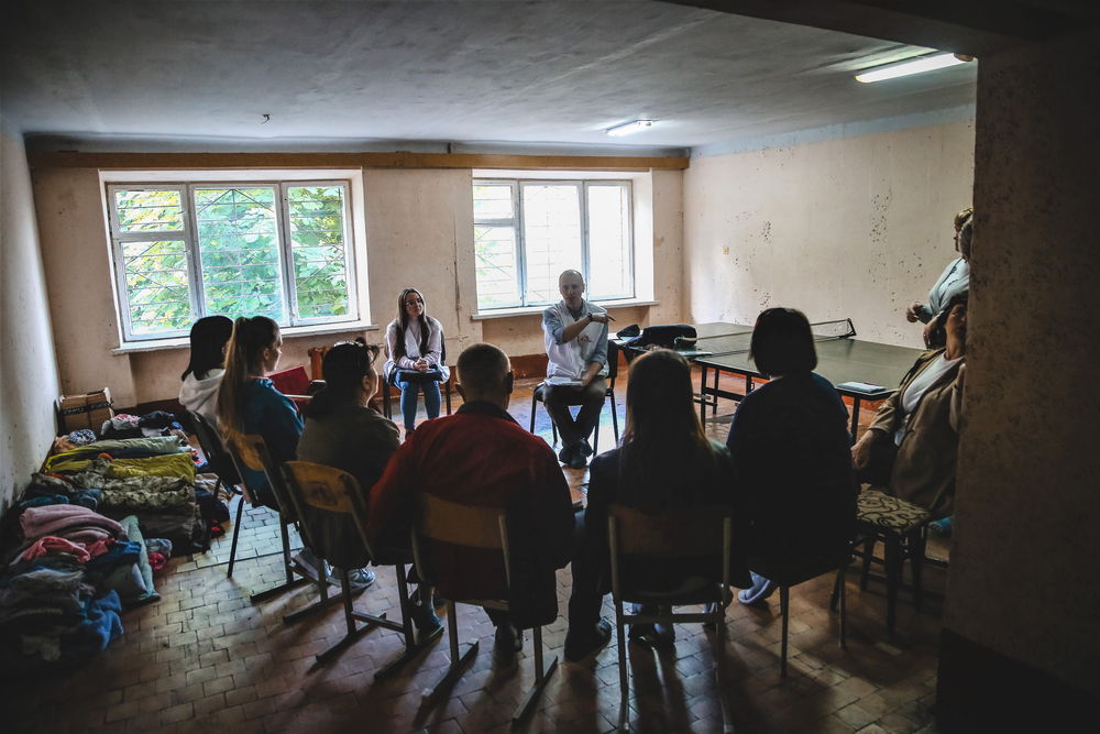 Personas desplazadas procedentes del este de Ucrania asisten a una sesión de psicoeducación facilitada por Ihor Ohdansky, psicólogo de MSF, en una residencia de estudiantes donde se alojan en la ciudad de Ivano-Frankivsk, en el suroeste del país. © Igor Barbero/MSF