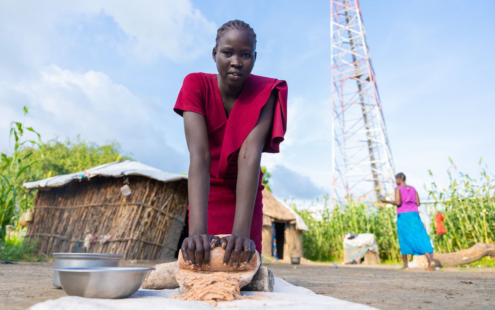 Nyamal Simon grinds sorghum grains to prepare for the evening meal at her home in Lankien, South Sudan | Date taken: 28/08/2024 | Photographer: Isaac Buay