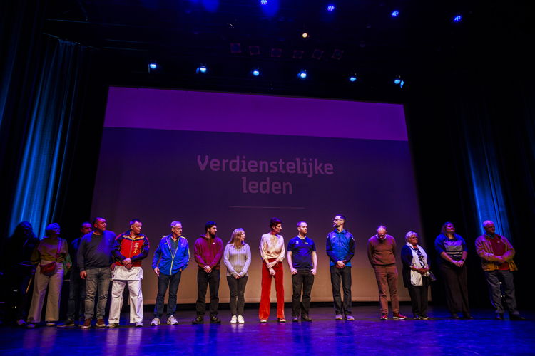 Verdienstelijke sportclubleden worden in de bloemetjes gezet. 