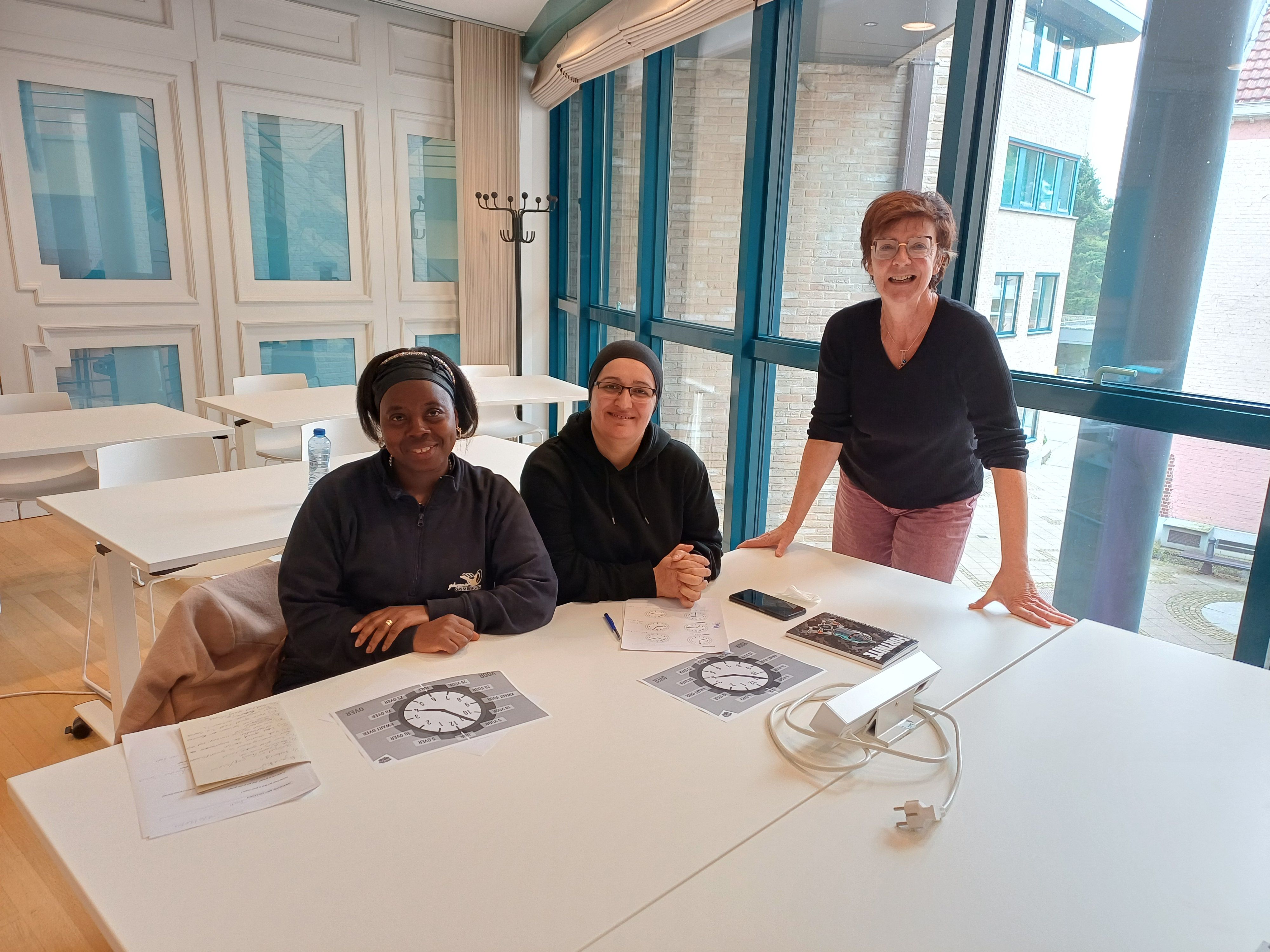 Joan en Aynur spijkeren hun kennis van het Nederlands bij met taalcoach Ingrid.