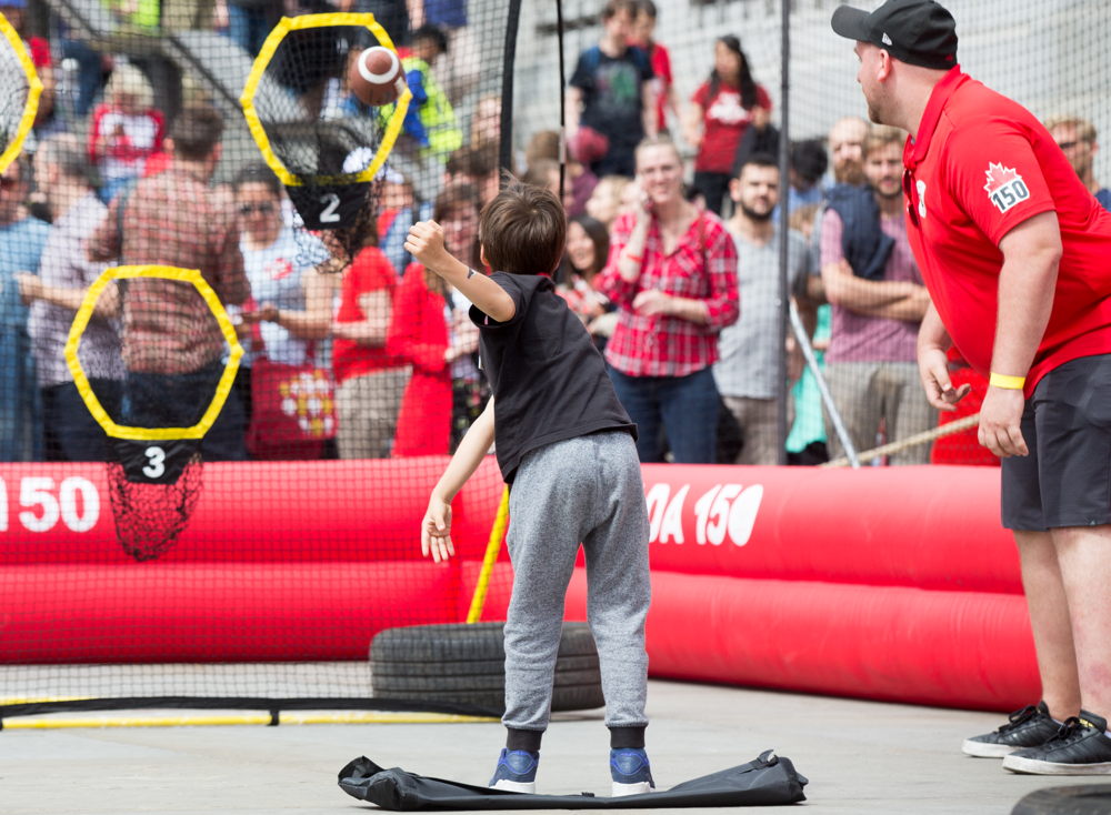 A young boy knocking out one of the targets in the obstacle course. Photo Credit: Jim Ross/CFL