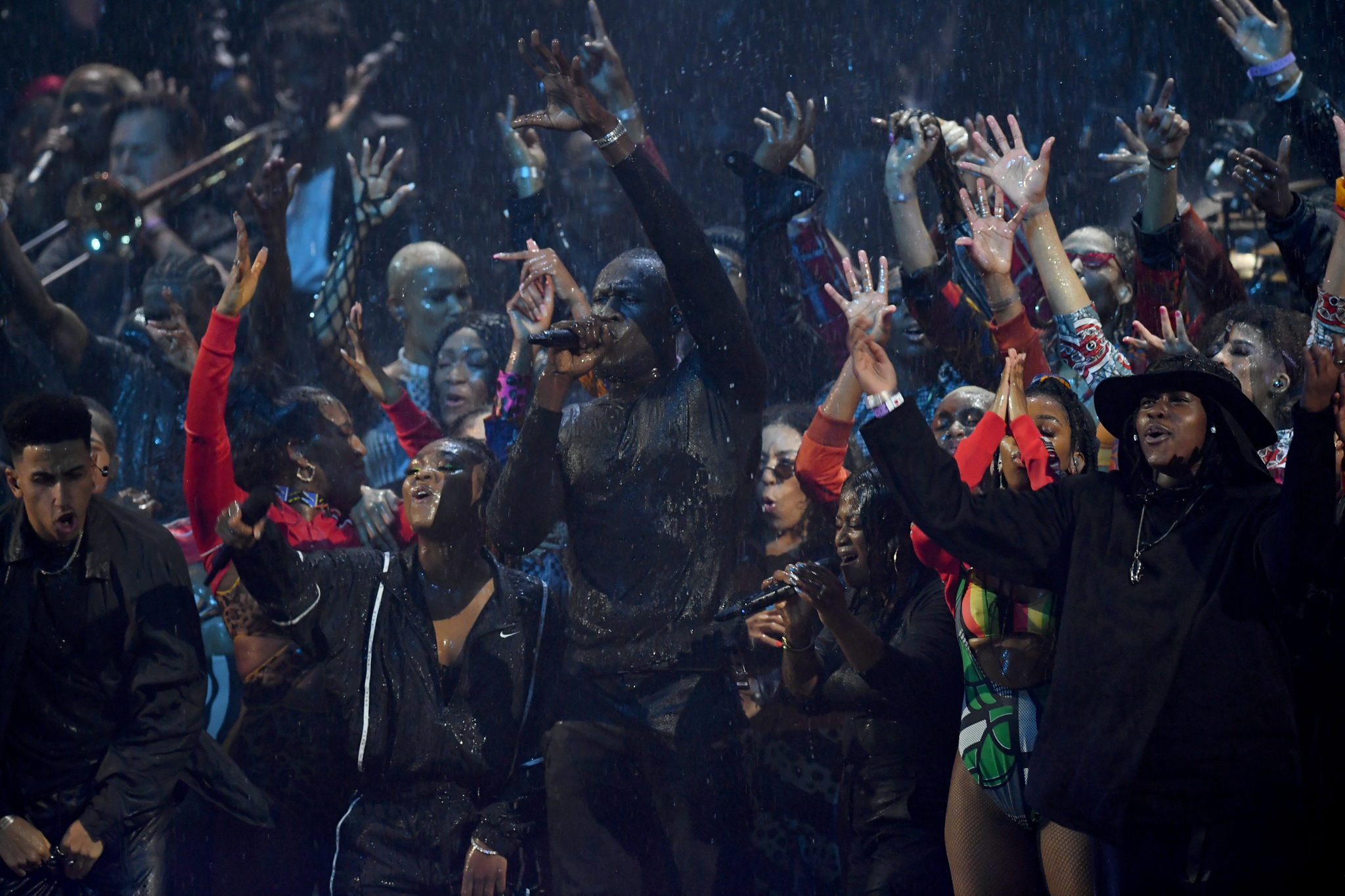 Rainfall: Stormzy, Tiana Major9 and Teni Tinks perform with their
SKM 6000 / MD 9235 wireless microphones under a wall of rain
(Photo credit: Getty Images) Rainfall: Stormzy, Tiana Major9 and Teni Tinks perform with their
SKM 6000 / MD 9235 wireless microphones under a wall of rain
(Photo credit: Getty Images)