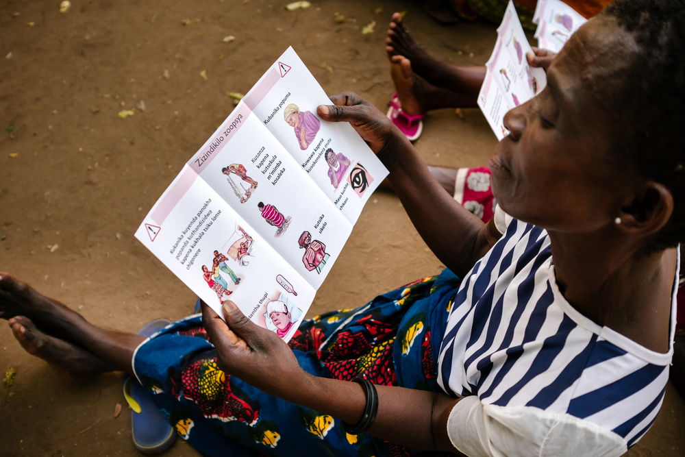 Una mujer lee un folleto con las señales de alerta para detectar el VIH. Isabel Corthier/MSF