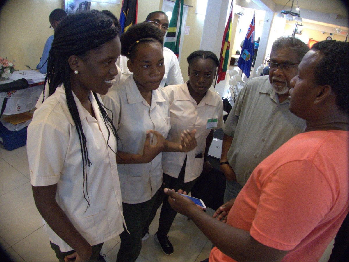 Farmer, Garvey Charlemagne, demonstrates ICTs on his mobile phone as a networking tool Sir Arthur Lewis Community College Students.