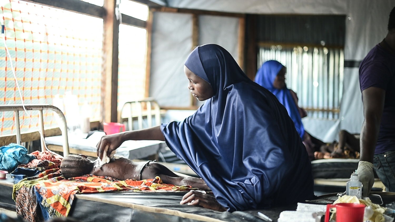 Une mère prend soin de sa fille qui souffre de la rougeole dans la salle d’isolement de l’hôpital général de Damboa, dans l’Etat de Borno au Nigeria. ©Ikran N’gadi