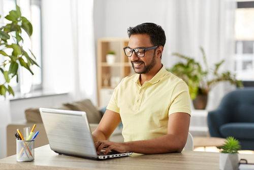 Man smiling and working on laptop. Man smiling and working on laptop.