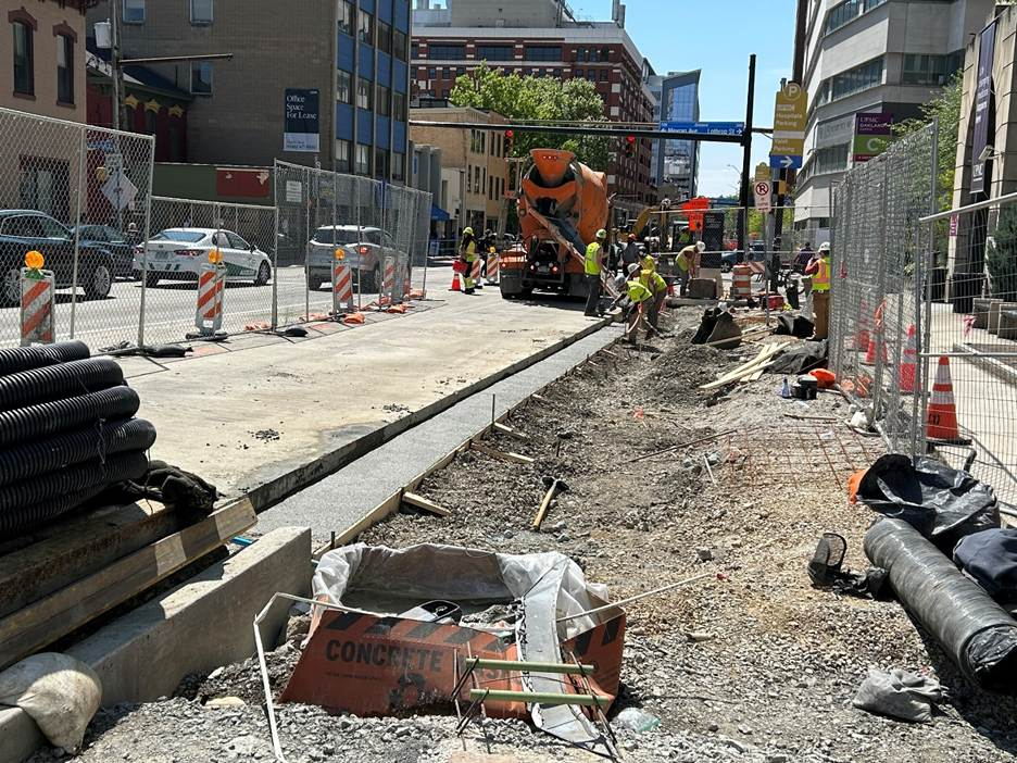 Crews install new road base along the edge of the future expanded sidewalk between Atwood Station and Falk Clinic on Fifth Avenue in Oakland Crews install new road base along the edge of the future expanded sidewalk between Atwood Station and Falk Clinic on Fifth Avenue in Oakland