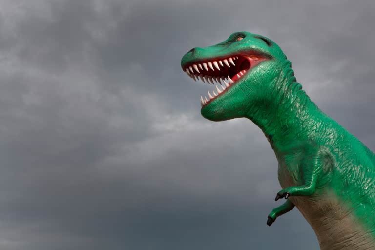 Dinosaur on display beneath a stormy sky, Barcelona. AKG2296134 © akg-images / Manuel Cohen
