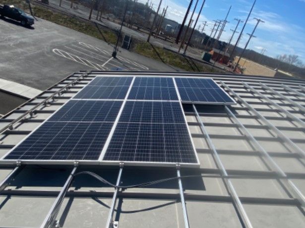  To power the new EV chargers at Woods Run, solar panels have been mounted on a curved, metal rooftop.