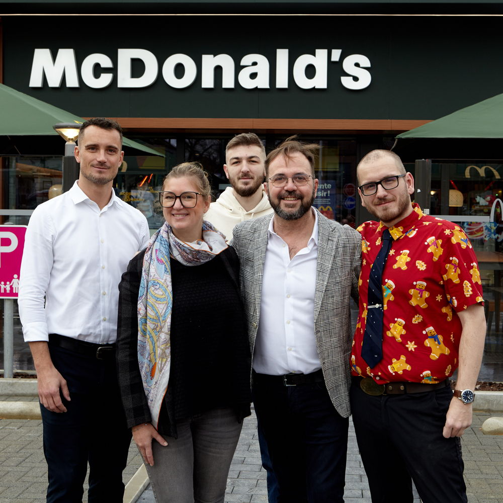 Valérie Bovy, franchisée du McDonald's d'Eghezée, accompagnée de Rudy Delhaise, bourgmestre d'Eghezée (à sa droite), et d'une partie de l'équipe