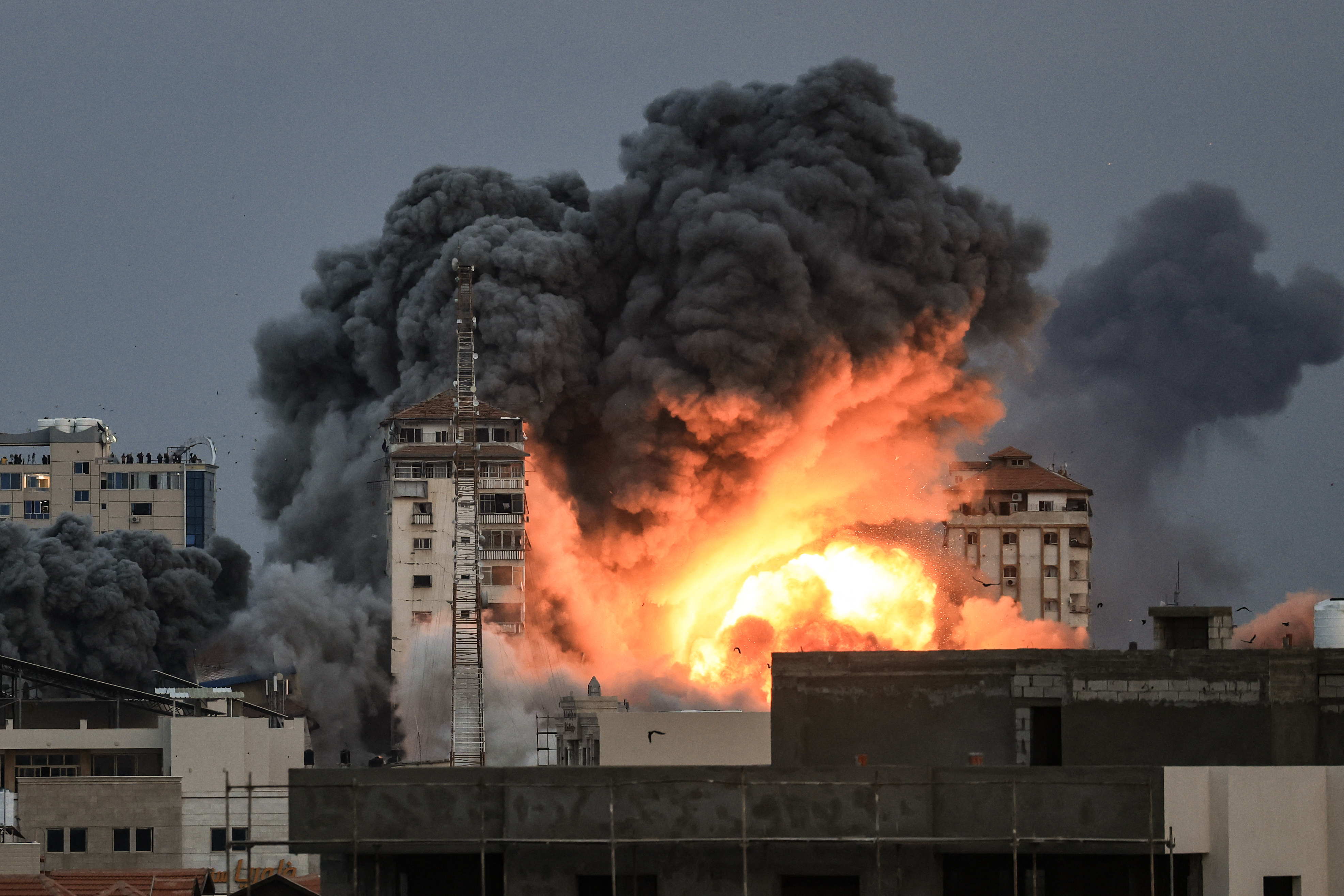 Una bola de fuego y humo se eleva sobre un edificio en la ciudad de Gaza el 7 de octubre de 2023 durante un ataque aéreo israelí que alcanzó el edificio Palestine Tower. © Mahmud Hams/AFP Una bola de fuego y humo se eleva sobre un edificio en la ciudad de Gaza el 7 de octubre de 2023 durante un ataque aéreo israelí que alcanzó el edificio Palestine Tower. © Mahmud Hams/AFP