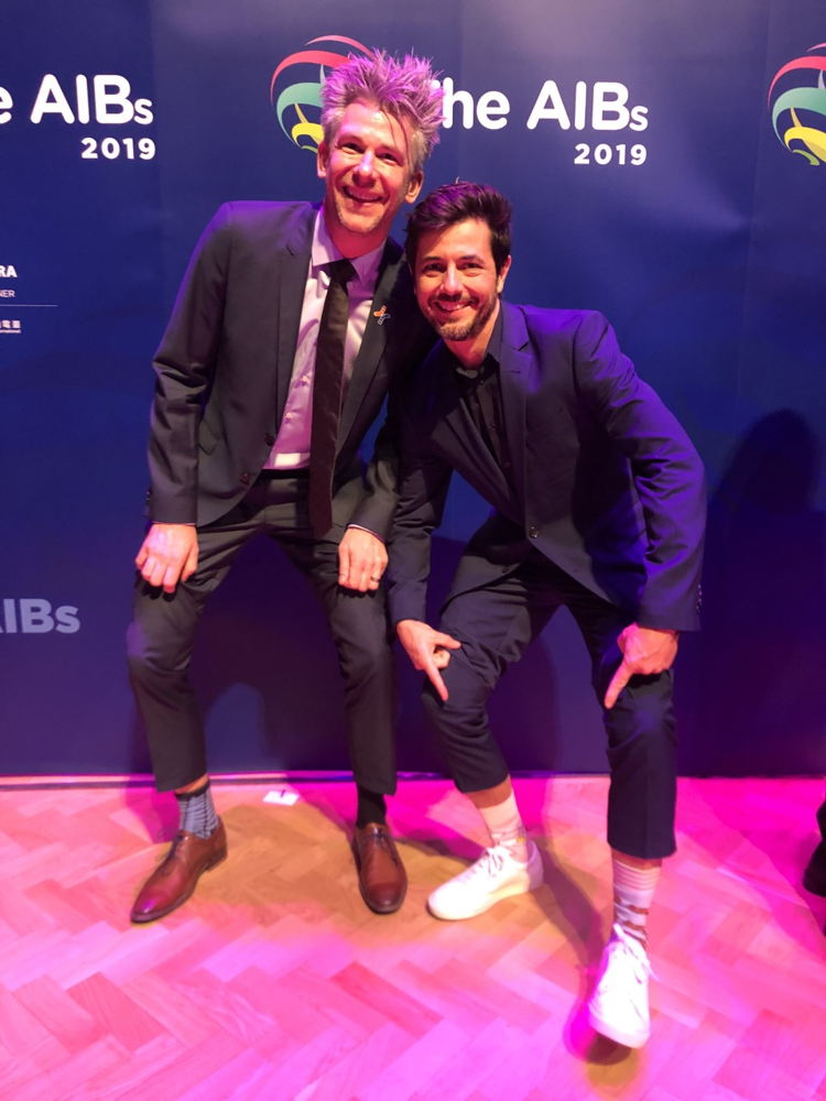 Dieter en Gijs tonen hun 2 verschillende sokken (symbool van Wereld Downsyndroomdag)