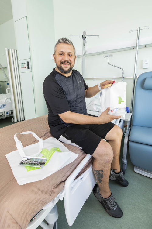 Een van de eerste patiënten in ZNA Cadix toont zijn welkomstpakket. (Foto: ZNA / Dirk Kestens)