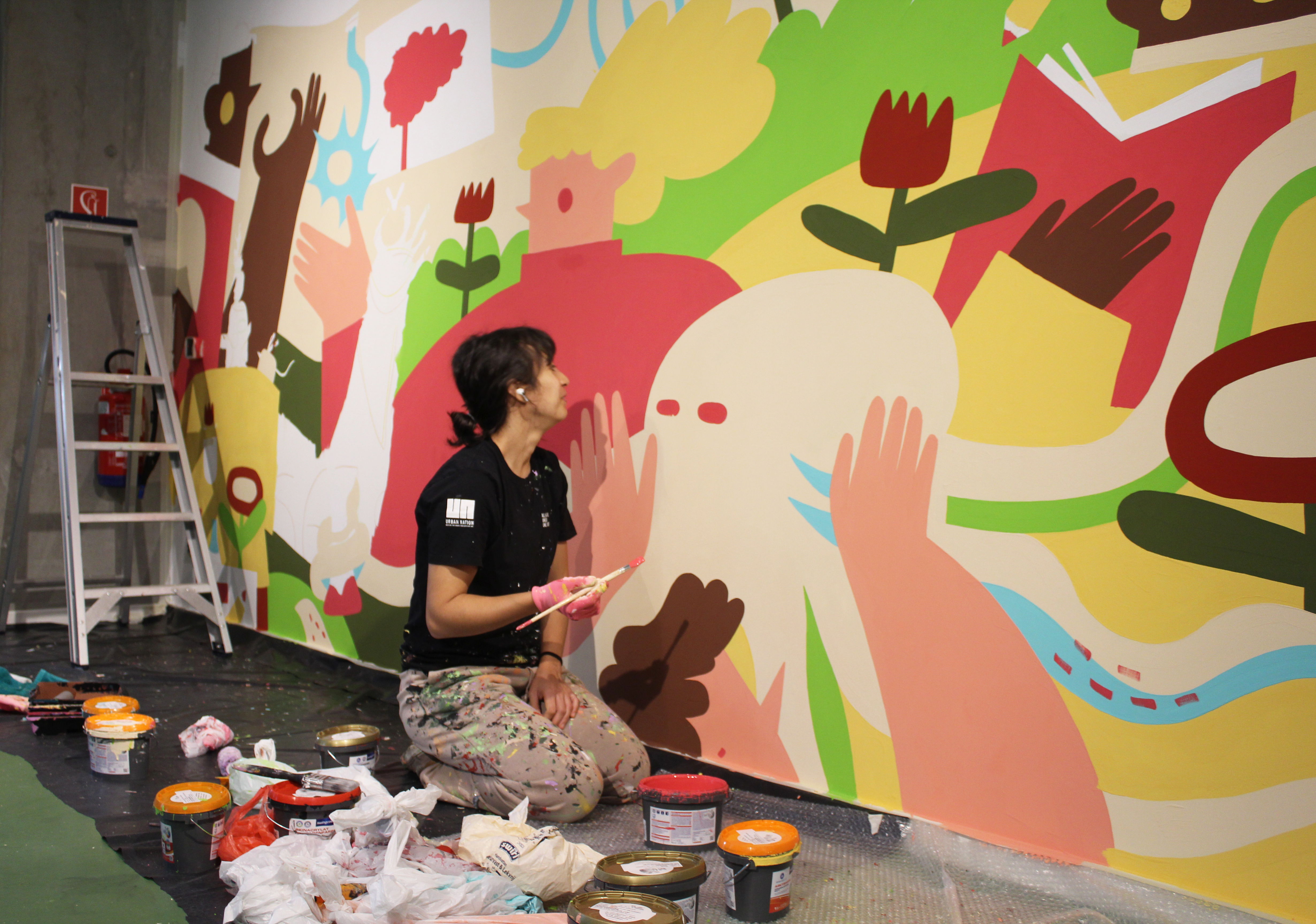 Júlia, in the process of creating the mural