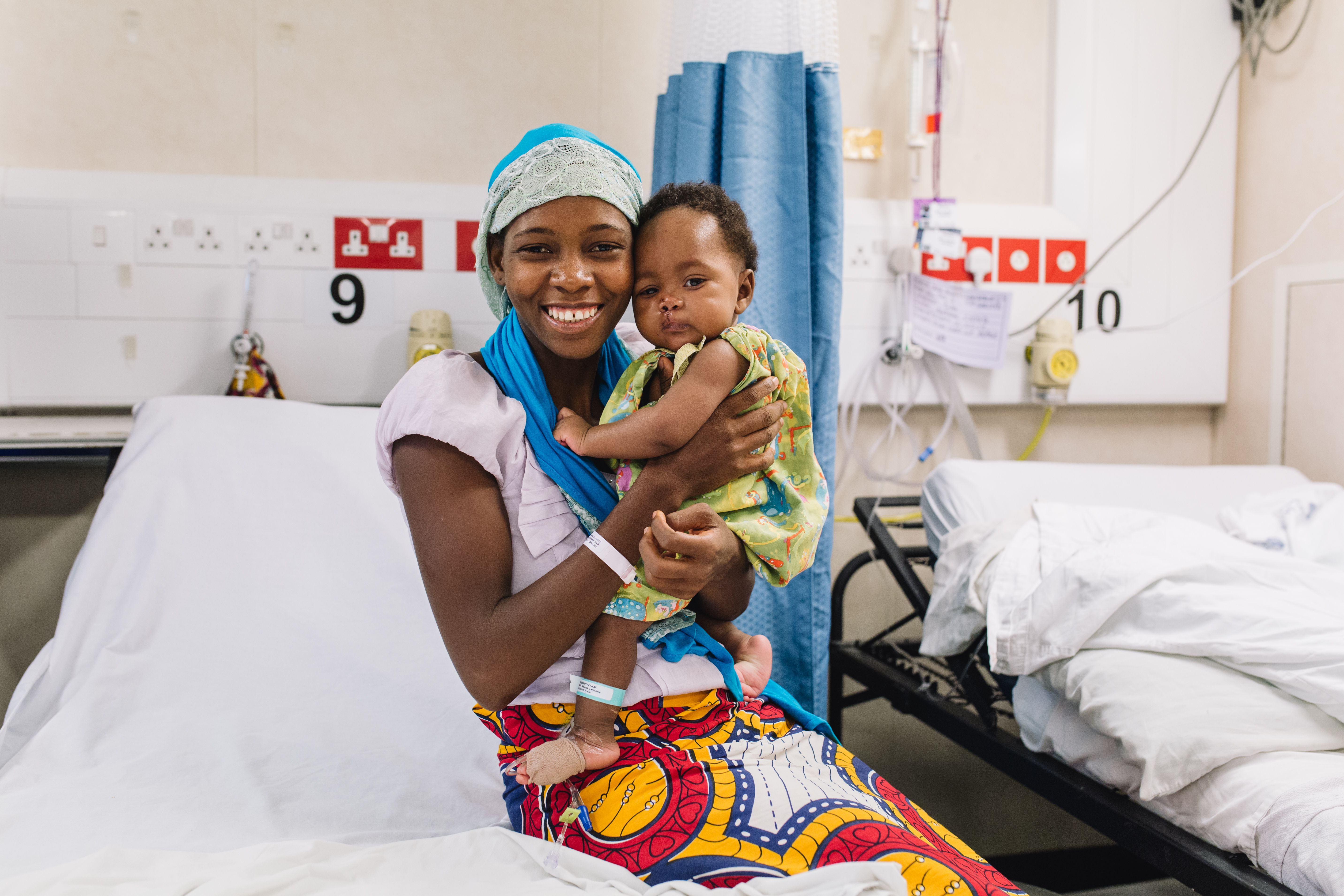 Hassanatou trägt Aissata nach ihrer Operation an Bord der Africa Mercy.